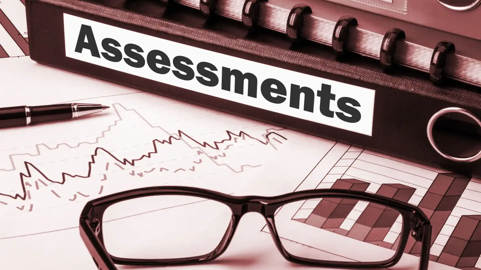Eyeglasses on a financial assessment document with charts.