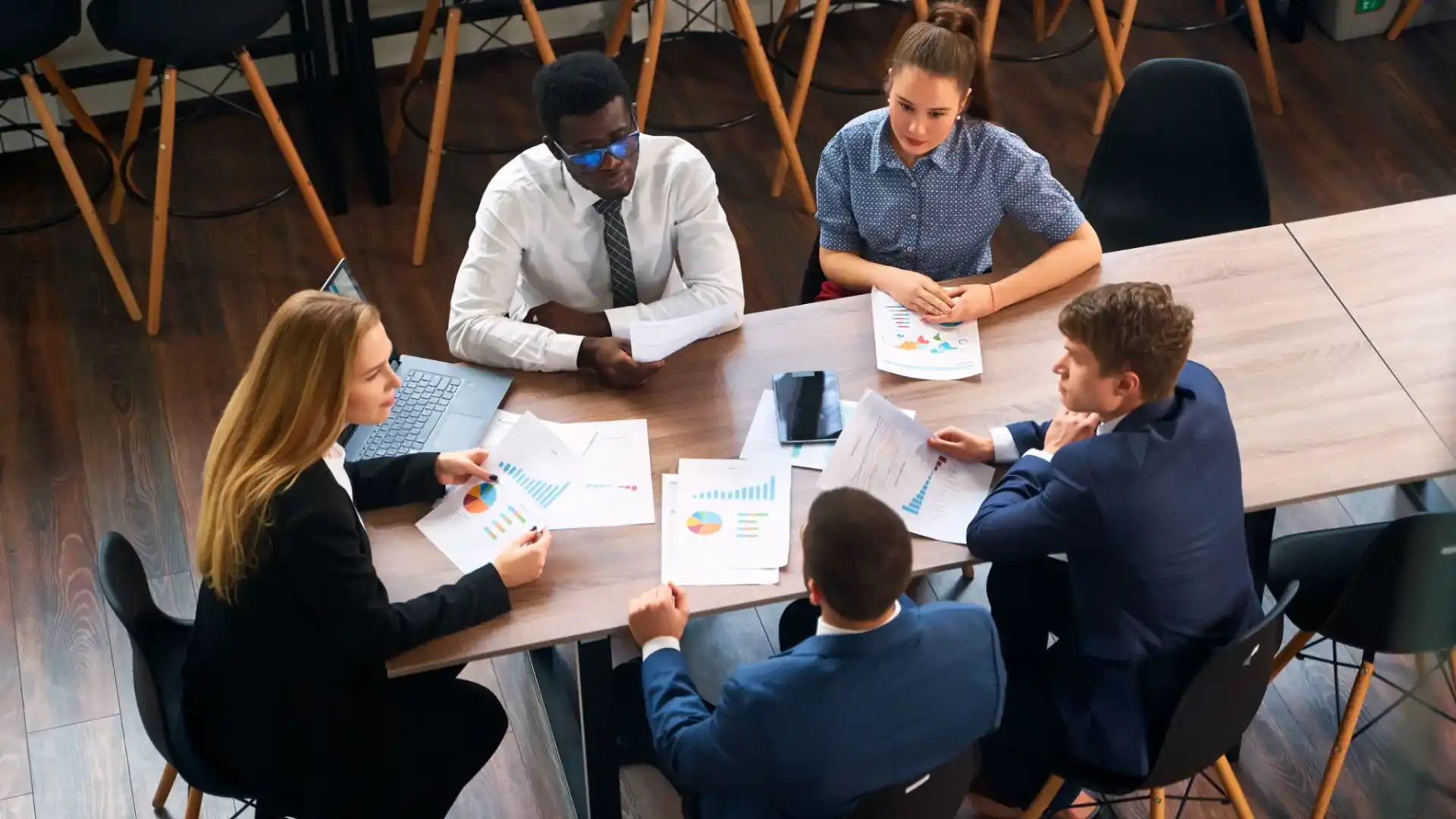 A group of professionals discussing documents around a table.