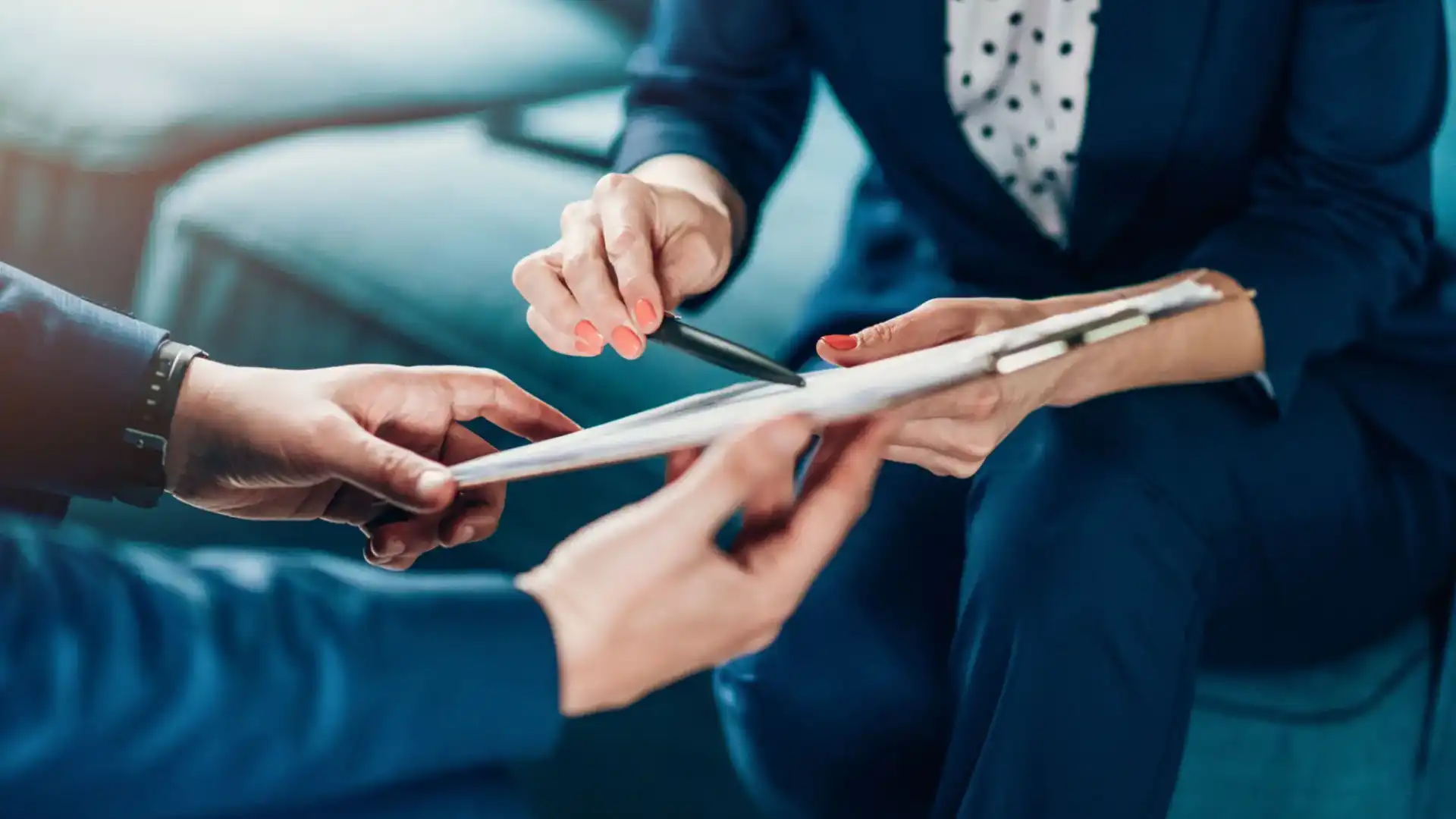 Two business professionals discussing documents with a pen and tablet.