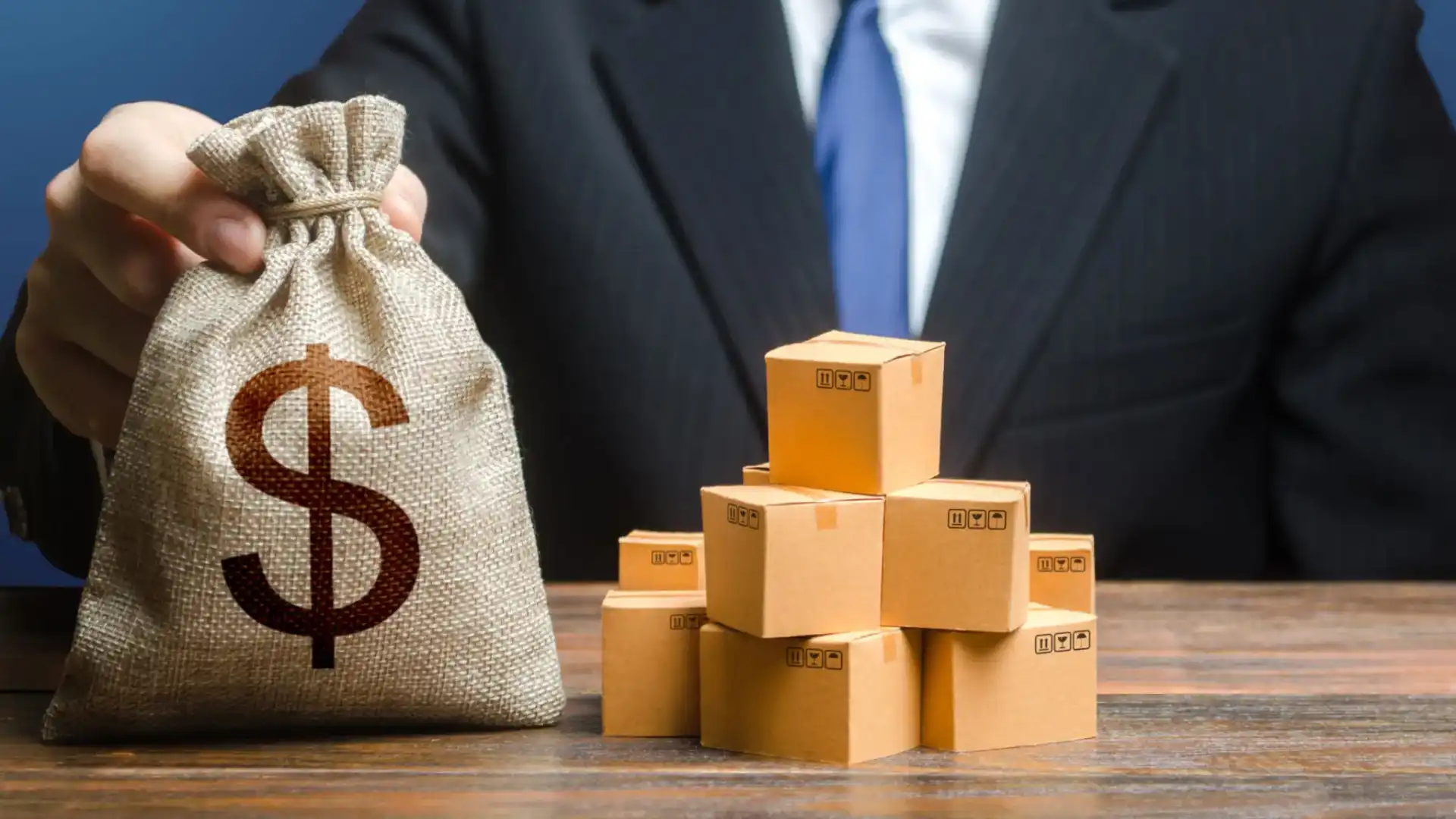 Businessman with money bag and stacked boxes symbolizing wealth.