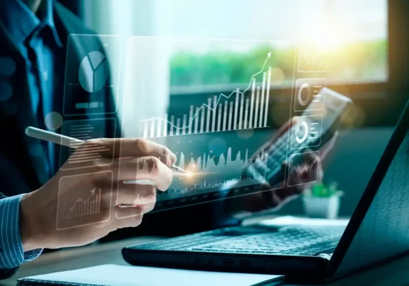 Person analyzing financial data on a transparent digital screen.