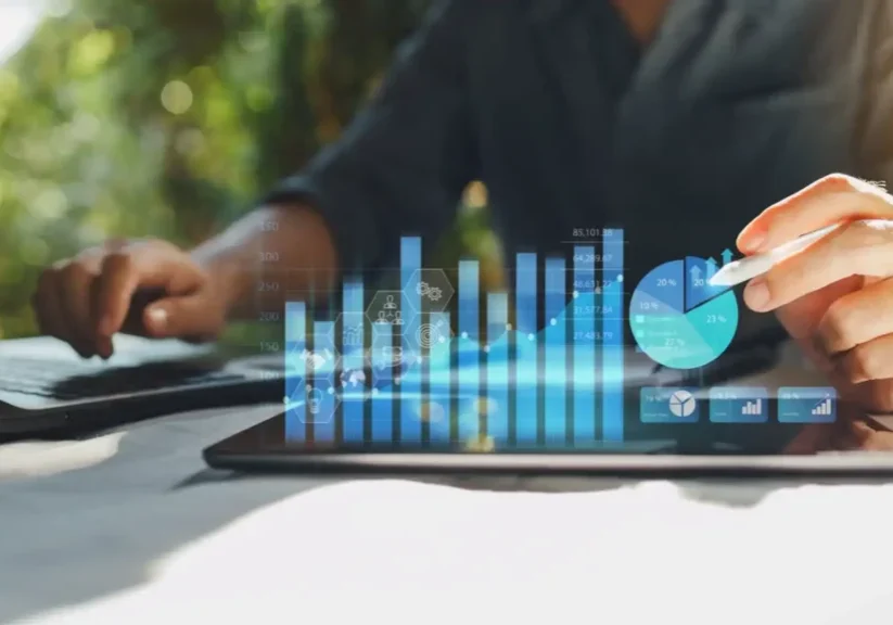 Business professionals using tablet with digital financial charts overlay.