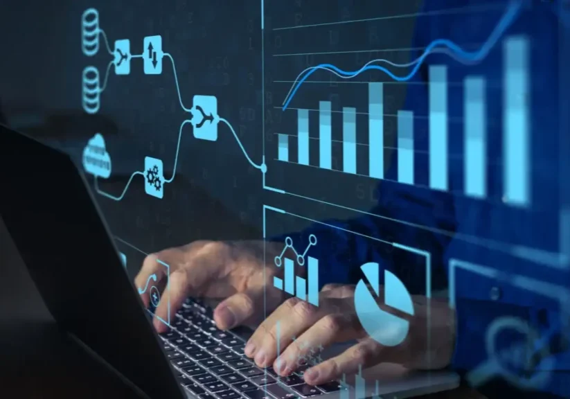 Hands typing on a laptop with digital financial charts overlay.